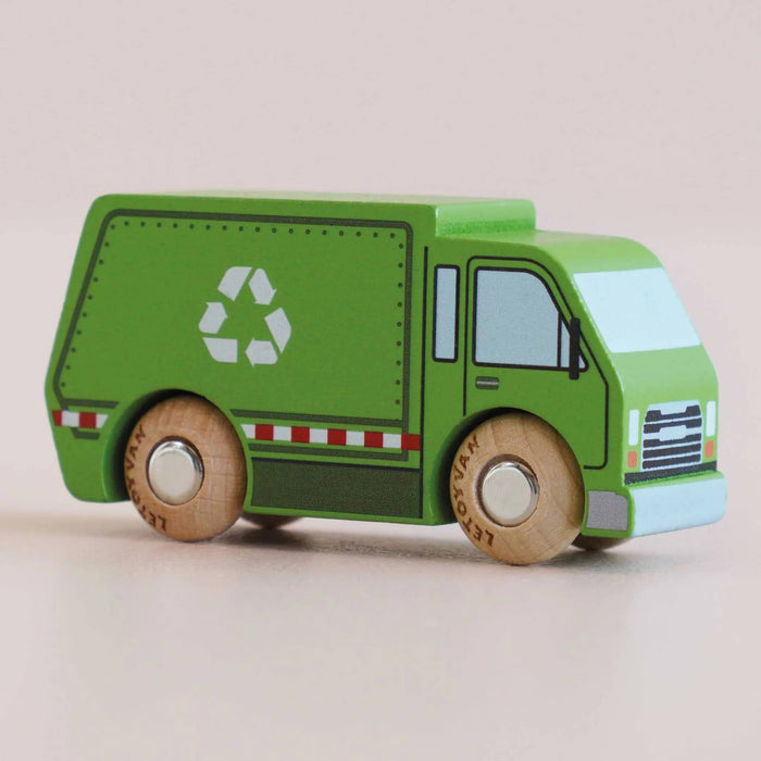A small wooden toy recycling truck in green with natural wood wheels, front angle view, on a plain light beige background.