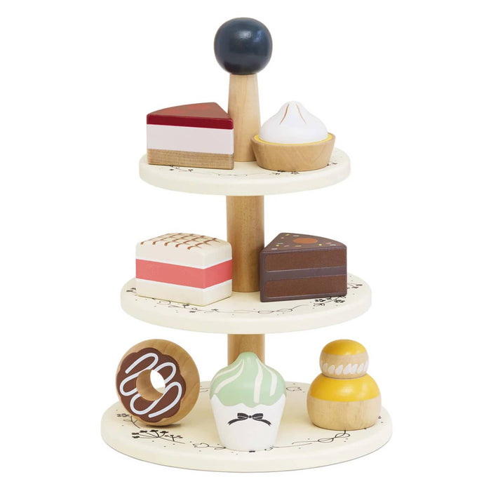 Wooden toy dessert set with multiple tiers on a white background.