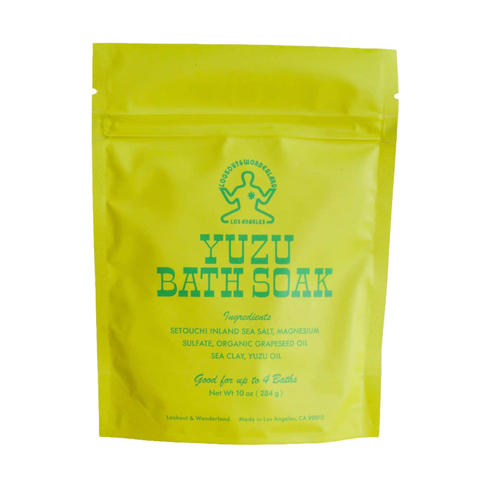 A bright yellow stand-up pouch of Lookout & Wonderland Yuzu Bath Soak with green text and logo, photographed on a plain white background.