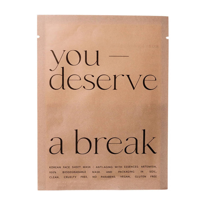 A single sheet mask package in a matte tan pouch with black text reading 'you deserve a break' on a plain white background.