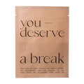 A single sheet mask package in a matte tan pouch with black text reading 'you deserve a break' on a plain white background.