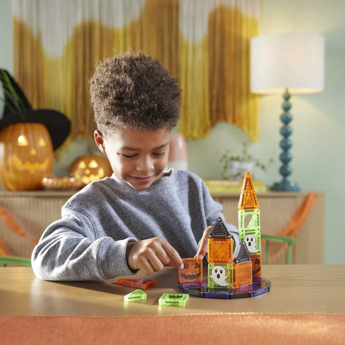 Child playing with Halloween-themed building blocks in a cozy room.