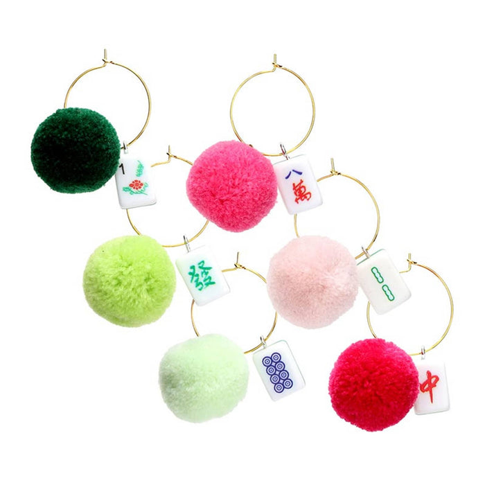 Set of colorful pom-pom and mahjong tile drink charms, on a white background.