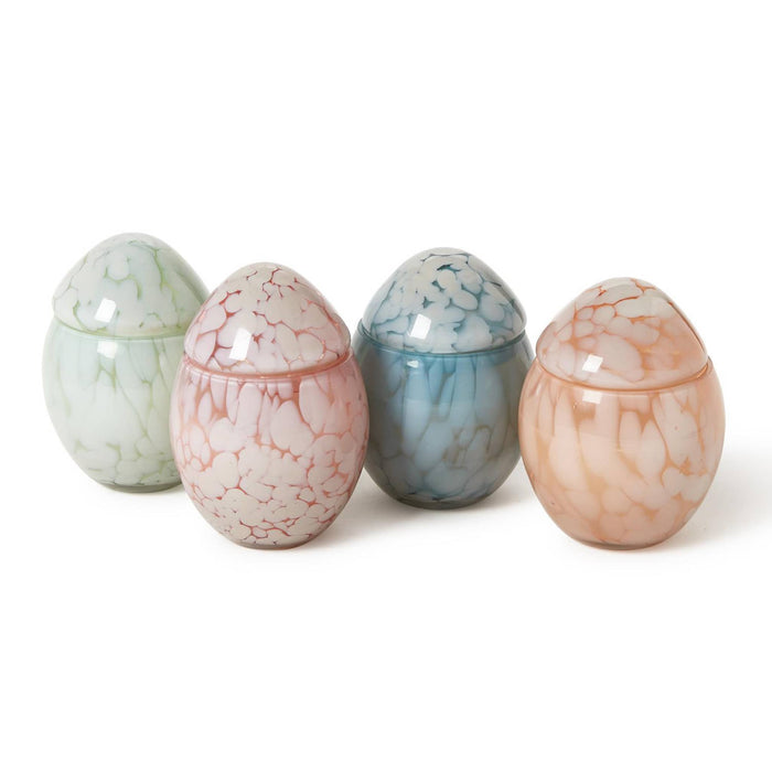 Four marbled egg-shaped glass containers on a white background.