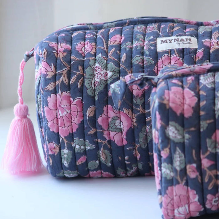 Floral patterned cosmetic bag with pink tassel on a white background.