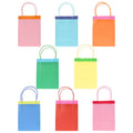 8 colorful paper favor bags with handles and fringe detail on a white background.