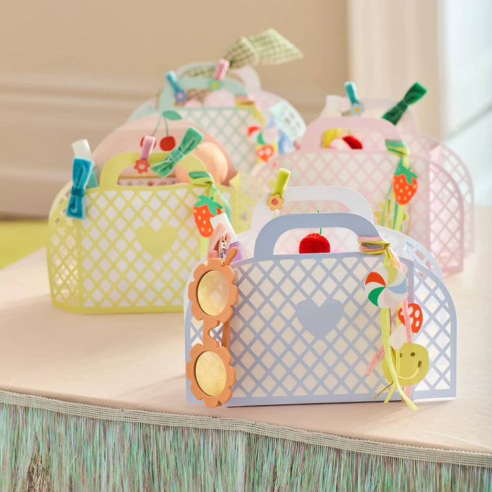 Colorful paper gift bags with decorative elements on a wooden surface.