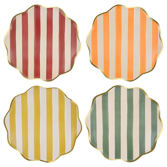 Four scalloped-edge large paper plates arranged in a 2x2 grid on a white background, each featuring vertical stripes in a different color combination: muted red and cream, orange and cream, mustard yellow and cream, and sage green and cream, all with gold trim.
