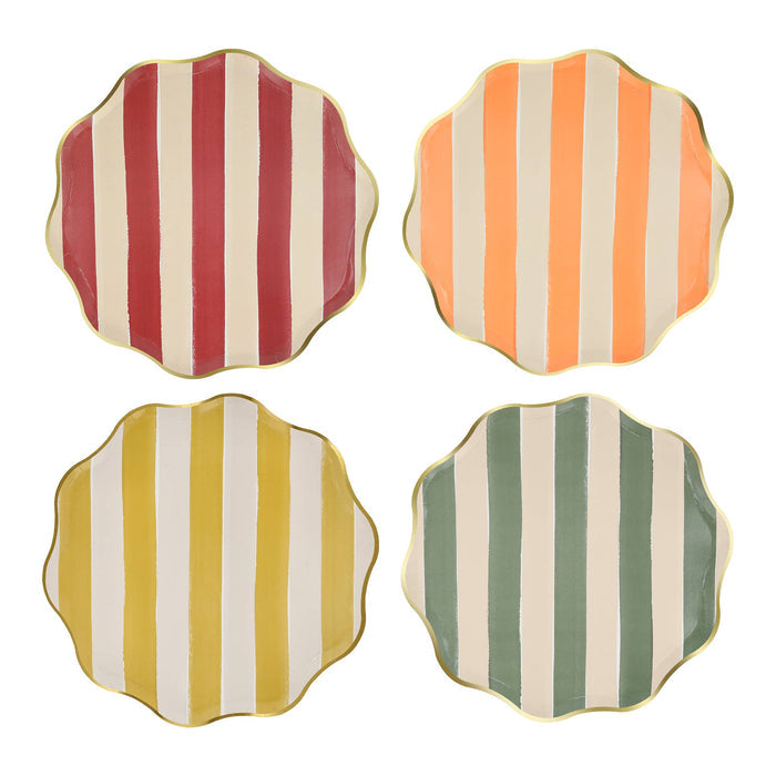Four scalloped-edge small paper plates arranged in a 2x2 grid on a white background, each featuring vertical stripes in a different color combination: muted red and cream, orange and cream, mustard yellow and cream, and sage green and cream, all with gold trim.
