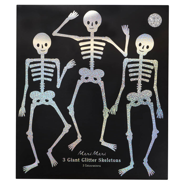 A black square envelope featuring three glittery skeleton decorations with the text 'Meri Meri 3 Giant Glitter Skeletons' on a white background.