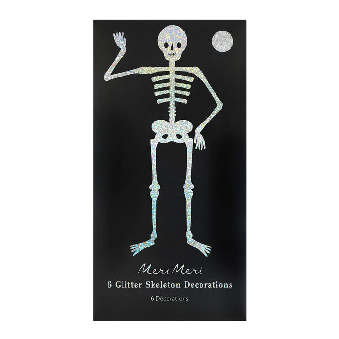 A black rectangular envelope featuring a glittery skeleton decoration design with the text 'Meri Meri 6 Glitter Skeleton Decorations' on a white background.