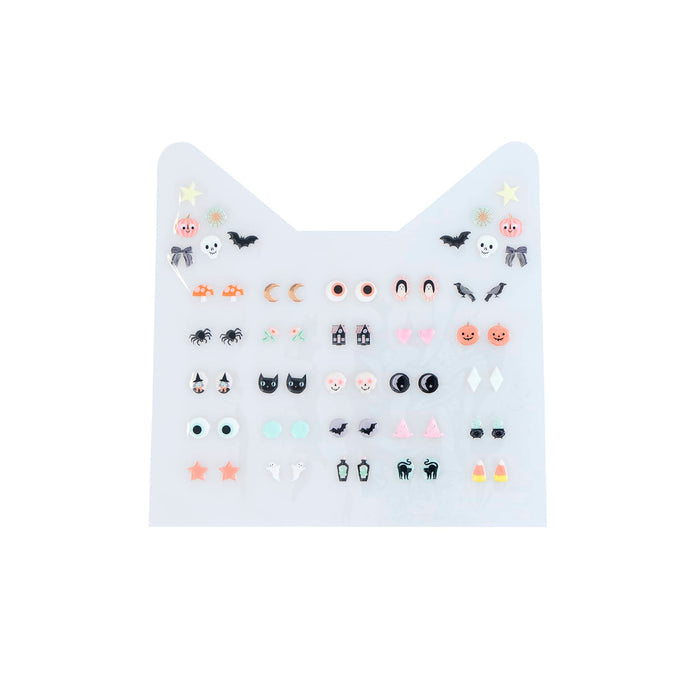 A sheet of small Halloween-themed decorative earring stickers on a white background, featuring faces, moons, bats, stars, and small icons in pastel and black colors.