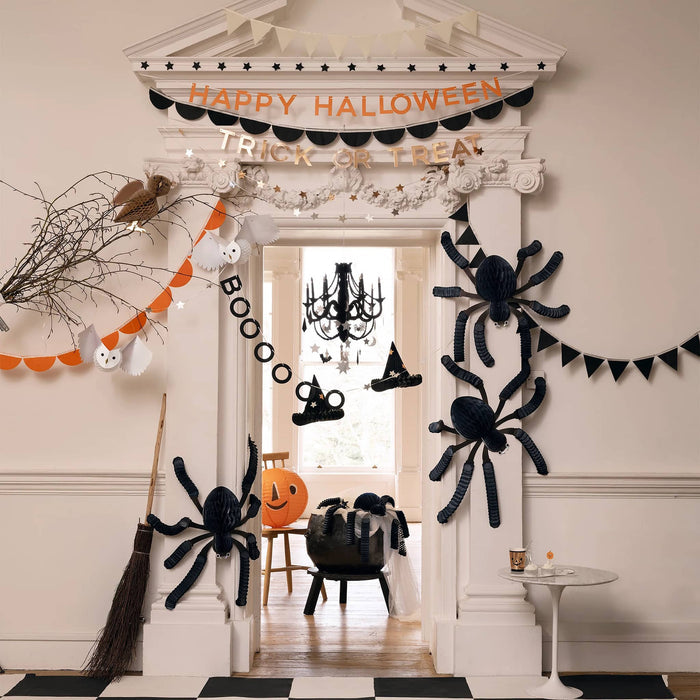 Halloween-themed room decor with spider webs, pumpkins, and a broom.