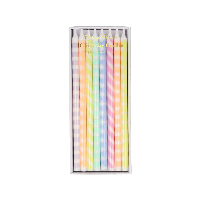 Pack of pastel-colored birthday candles with patterns in a clear box on a white background.