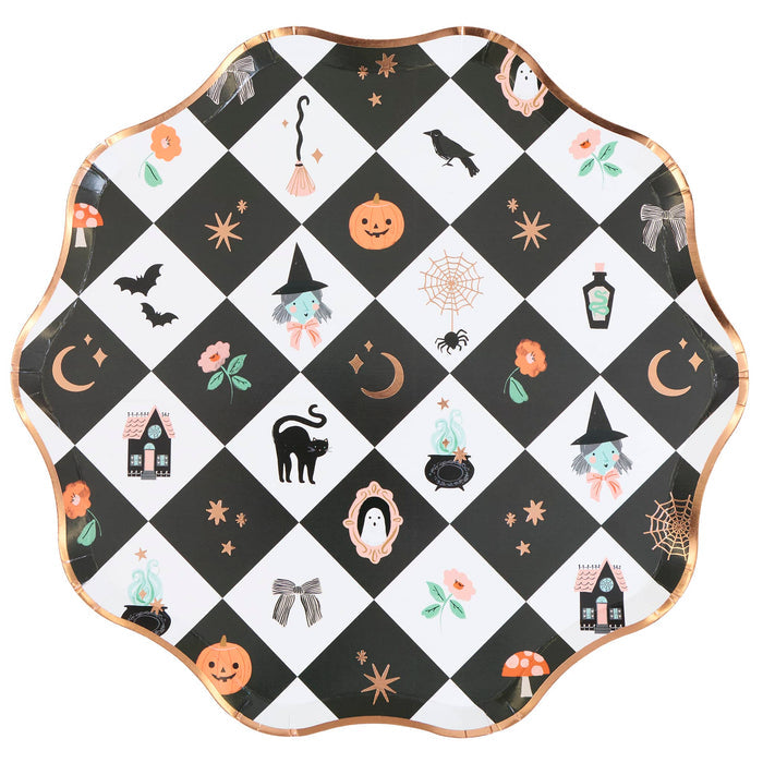 A scalloped round paper plate with a black and white checkered pattern decorated with various cute Halloween illustrations, including pumpkins, witches, ghosts, spiders, and mushrooms, finished with a metallic rose gold rim.