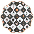 A scalloped round paper plate with a black and white checkered pattern decorated with various cute Halloween illustrations, including pumpkins, witches, ghosts, spiders, and mushrooms, finished with a metallic rose gold rim.