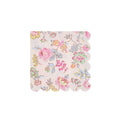 Pink decorative small paper napkin with delicate pastel floral print and scalloped edge, on a white background.