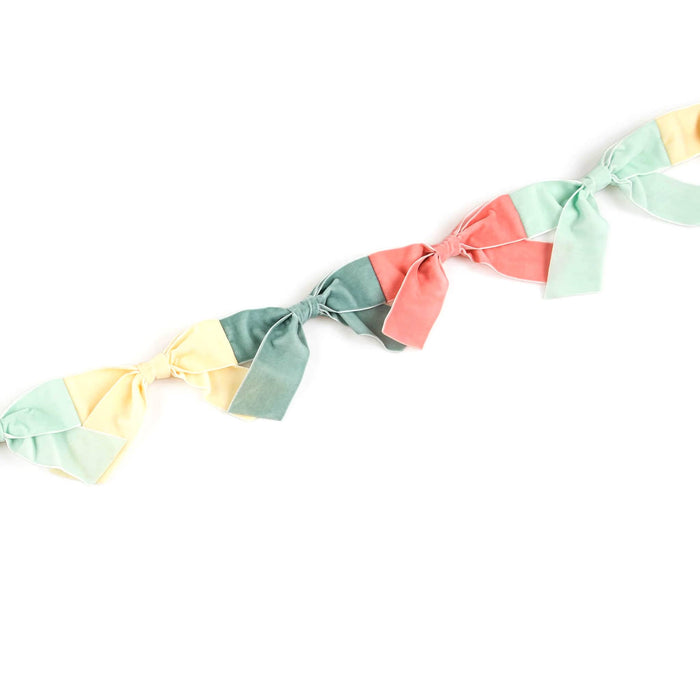 Colorful velvet bow garland on a white background.