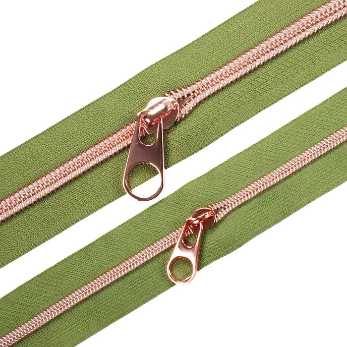 Muted shade of green zipper tape with rose gold coil teeth and a pop tab pull. The size #5 zipper tape is shown above it.