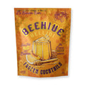 Front of packaging of Beehive Bellini frozen cocktails with honeycomb design with lemon and peach illustration, on a white background.