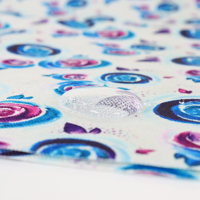 This printed WPC-Lite is of watercolor roses in purple, blue, and pink. This photo shows a water drop on the fabric.