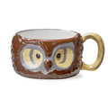A large ceramic owl-shaped mug with a brown textured body, large yellow and gray eyes, and a beige handle, shown on a white background.