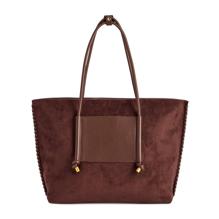 A dark brown vegan suede tote bag with a smooth brown vegan leather front pocket and matching shoulder straps, finished with small gold-tone hardware, front view shown against a plain white background.