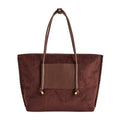 A dark brown vegan suede tote bag with a smooth brown vegan leather front pocket and matching shoulder straps, finished with small gold-tone hardware, front view shown against a plain white background.