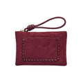 A dark red vegan suede pouch wallet with a front whipstitched pocket and a knotted leather wristlet strap, front view shown on a plain white background.