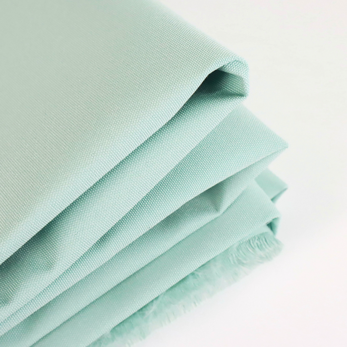 This ReNew Solid is a pale and soft shade of green with a blue undertone. This photo is of the fabric folded.