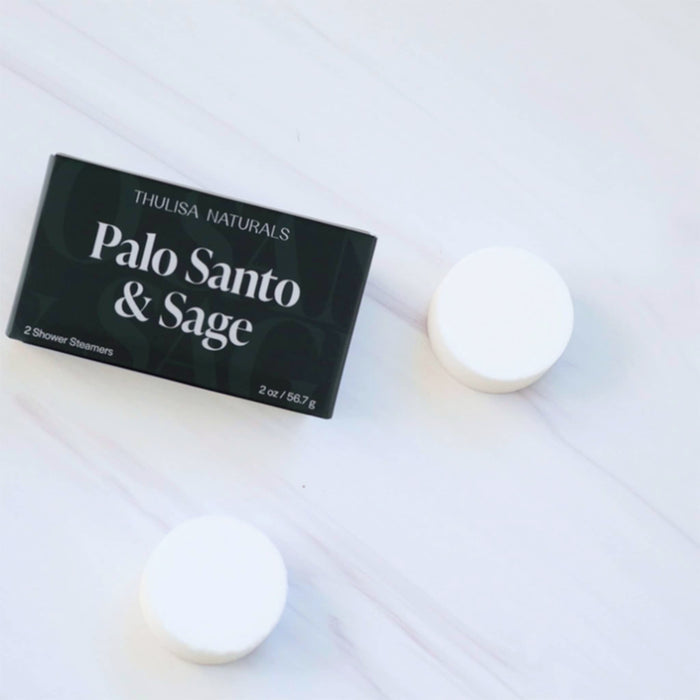 Thulisa Naturals Palo Santo & Sage shower steamers with packaging, on a white marble surface.