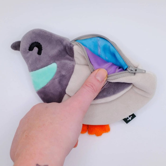 Plush toy with a zipper pocket held open by a hand on a white background.
