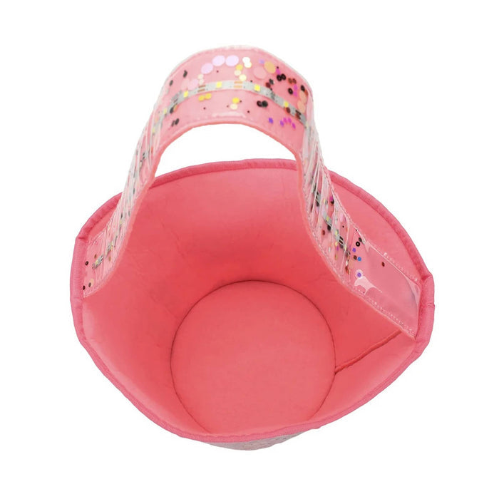 Overhead view of a pink bucket bag with a pink fabric handle filled with metallic confetti, shown against a plain white background.