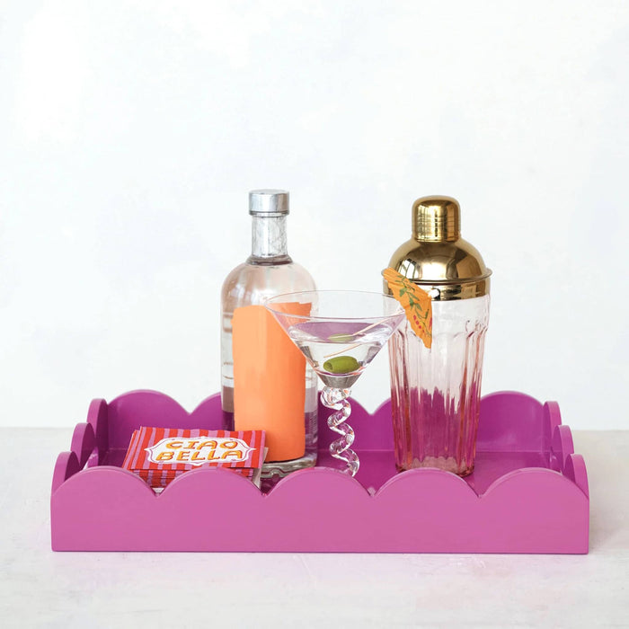 Creative Co-op MDF fuchsia lacquered rectangular scalloped serving tray, front view with a cocktail shaker, martini glass, cocktail napkins and a bottle.