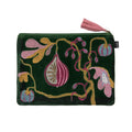 A dark green velvet zippered pouch featuring intricate hand-knotted botanical embroidery in pink, gold, and light blue, finished with a matching pink tassel zipper pull.