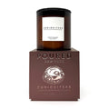 An amber glass jar candle with a black lid and white label reading 'CURIOSITEAS' sits on top of a dark brown embossed box labeled 'POURED NEW YORK' and 'CURIOSITEAS'.