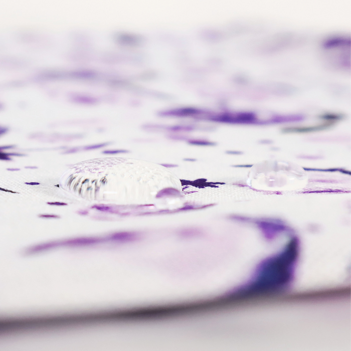 This printed WPC-Lite is of watercolor flowers in purple tones. This photo shows water droplets on the fabric.
