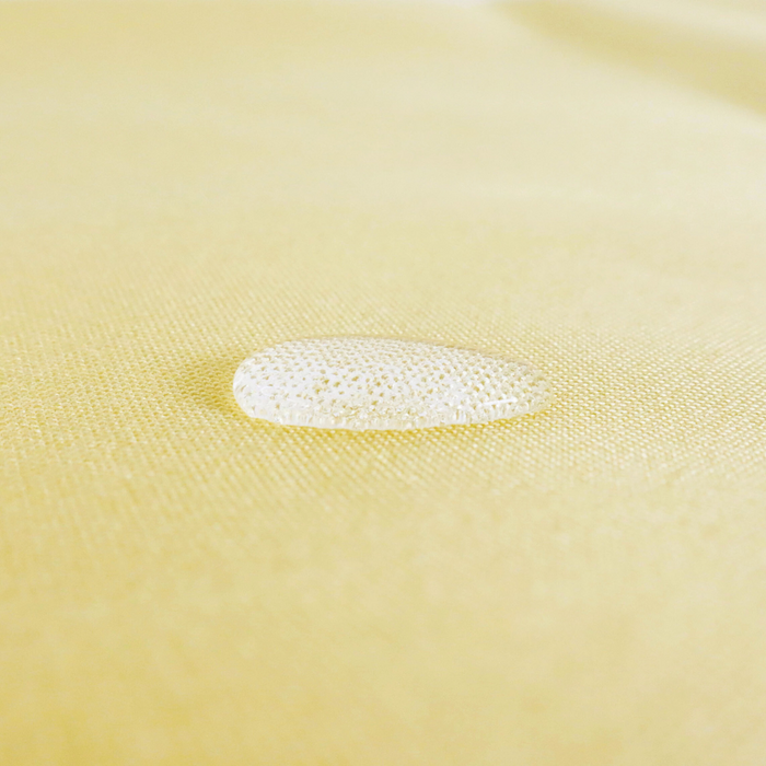 This WPC-Lite solid is a soft and pastel shade of yellow. This photo shows a water drop on the fabric.