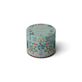 A round decorative tin candle with a light sage green background and an intricate floral and botanical pattern in red, yellow, and purple, featuring the text 'CHAMPS DE FRANCE' on the lid.
