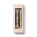 A boxed set of four gel pens by Rifle Paper Co. The product is shown in its original light pink packaging with a clear window displaying the patterned pen barrels inside.