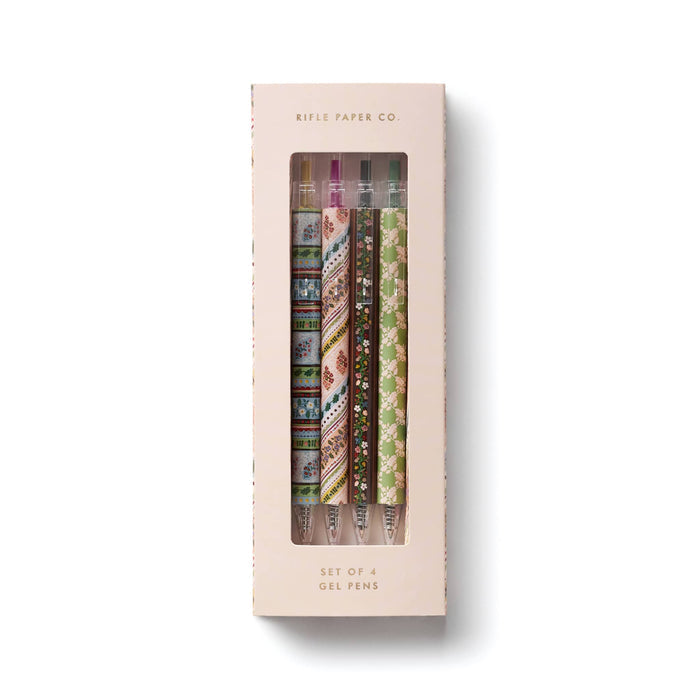 A boxed set of four gel pens by Rifle Paper Co. The product is shown in its original light pink packaging with a clear window displaying the patterned pen barrels inside.