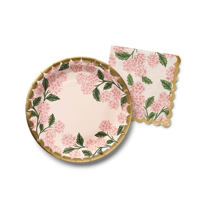 Pink hydrangea floral plate with matching napkin, overhead view, on a white background.