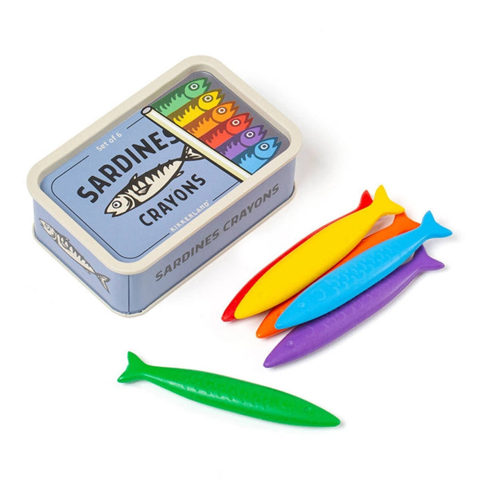 A set of colorful fish-shaped crayons displayed next to their blue tin packaging, which is labeled 'SARDINES CRAYONS'. The crayons include green, yellow, blue, orange, and purple, arranged on a clean white background.