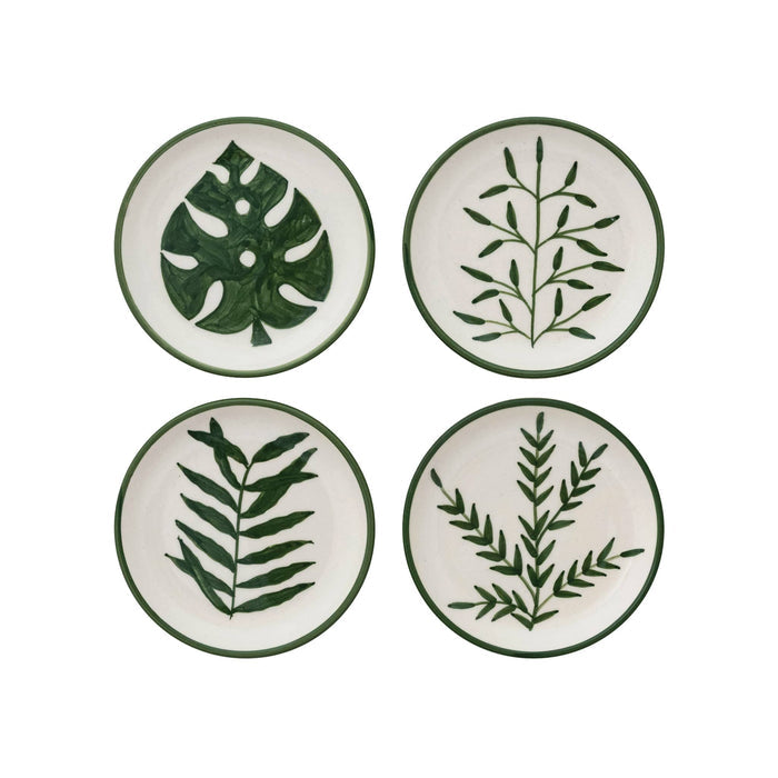 Four small round cream stoneware dish arranged in a 2x2 grid, each decorated with a different green botanical leaf pattern and a dark green rim.