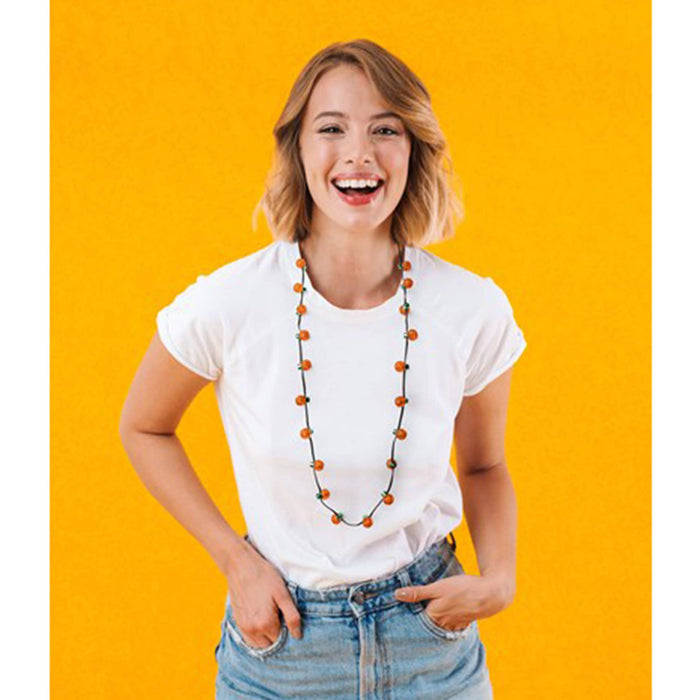 Spooky Lites light up necklace with 20 ultra bright mini pumpkin lights strung on a green cord shown on a female model with a white t-shirt, jeans and on a golden yellow background.