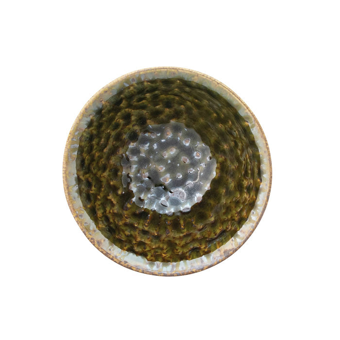 Overhead view of a handmade stoneware bowl with a textured glaze in earthy olive green and brown tones, on a white background.