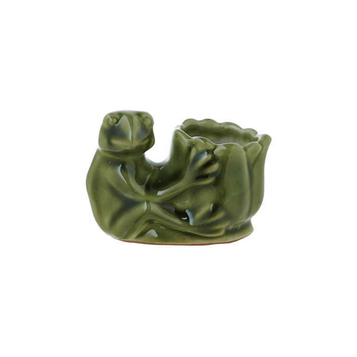 A small green glazed stoneware figurine shaped like a seated frog holding a lotus flower, photographed on a plain white background.