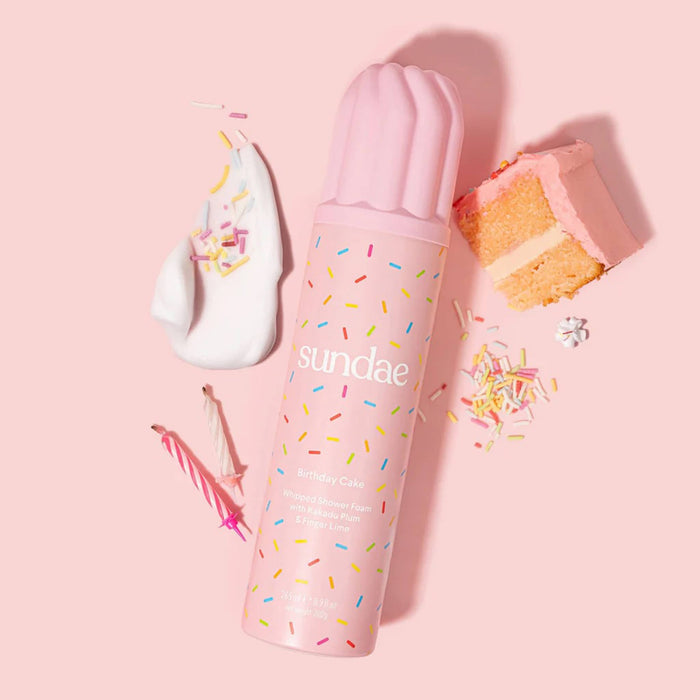Birthday Cake Whipped Shower Foam body wash in pink canister with cake, sprinkles and cream, on a pink background.
