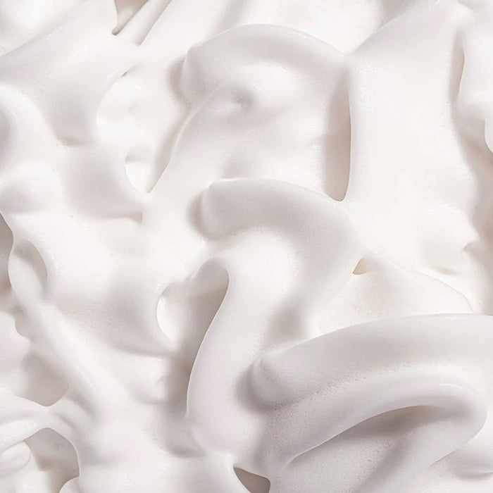 Close-up of white whipped shower foam body wash.