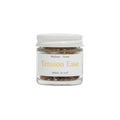 Tension Ease aromatherapy inhaler in a glass jar, front view, on a white background.
